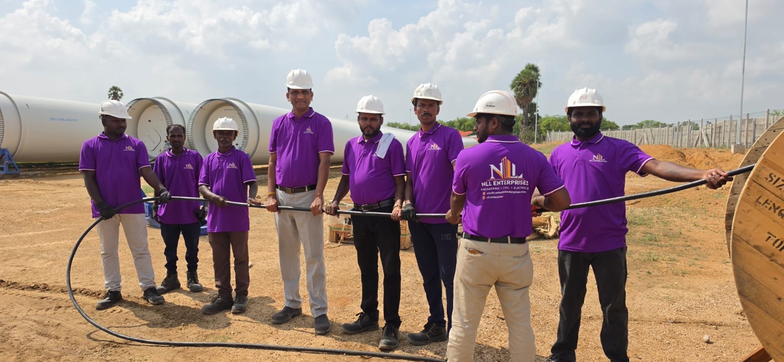 NLL Enterprises site team at cable drum and wind turbine blades